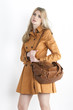 Photo: portrait of standing woman wearing brown coat with a handbag portrait of standing woman wearing brown coat with a handbag
