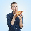 portrait of a young beautiful man eating a slice of pizza marghe