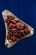 roasted cocoa chocolate beans on dark blue wood background