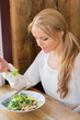Woman Eating Salad In Restaurant