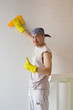 Young worker smoothing wallpaper with spatula