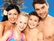 Happy family with two children at tropical beach