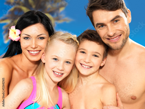 Photo: Happy family with two children at tropical beach Happy family with two children at tropical beach