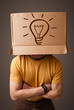Young man gesturing with a cardboard box on his head with light