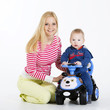 Mother with her baby boy sitting on his toy car