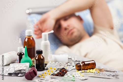 Photo: Unwell man patient lying down bed Unwell man patient lying down bed