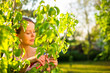 Photo: Pretty female gardener taking care of her lovely garden Pretty female gardener taking care of her lovely garden