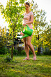 Photo: Pretty female gardener taking care of her lovely garden Pretty female gardener taking care of her lovely garden