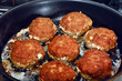 Meatballs frying in a pan.