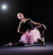 Ballerina dancing in the dark studio