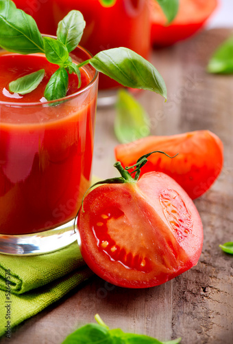 Photo: Tomato Juice and Fresh Tomatoes with Basil on a Wooden Table Tomato Juice and Fresh Tomatoes with Basil on a Wooden Table