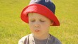 A little boy eating ice cream in a Panama hat on a background of