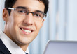 Smiling businessman working with laptop at office