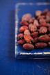 roasted cocoa chocolate beans on dark blue wood background