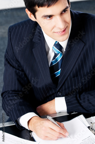 Photo: Portrait of writing businessman working at office Portrait of writing businessman working at office