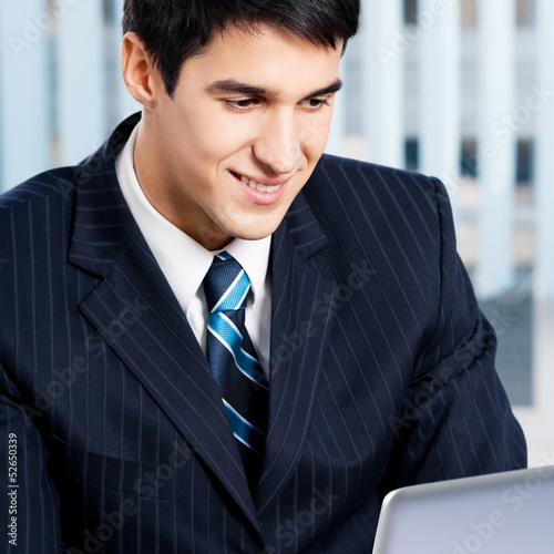 Photo: Businessman working with laptop at office Businessman working with laptop at office