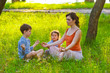 daughter mother and son sitting outdoors picnic meditation natur