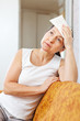 sick mature woman uses handkerchief