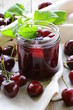 Cherry jam in a glass jar and ripe berries