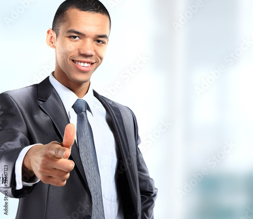 Photo: Young african business man giving thumb up, isolated on white Young african business man giving thumb up, isolated on white