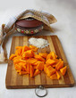 Slices of pumpkin on the board for cooking porridge in bitter go