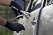 Car thief ,Shot of a male using a tool to break into a car.