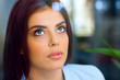 Closeup portrait of a young beautiful pensive woman