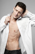 Photo: Handsome man in white shirt on gray. Handsome man in white shirt on gray.