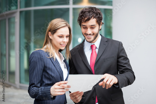Photo: Business people reading a document Business people reading a document