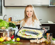 pretty  woman cooking fish  in sheet pan