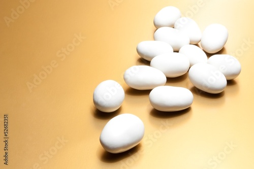 Photo: white jordan almonds on golden background white jordan almonds on golden background