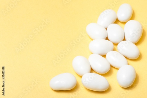 Photo: white jordan almonds on yellow background white jordan almonds on yellow background