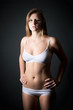 Schöne schlanke blonde Frau in weißer Unterwäsche