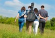 Photo: Four happy teenage friends boys and girls walking with guitar Four happy teenage friends boys and girls walking with guitar