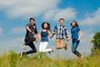 Photo: Four happy teenage friends jumping high in blue sky Four happy teenage friends jumping high in blue sky