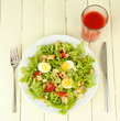 Caesar salad on white plate, on color wooden background