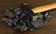 Coal with hummer on wooden background