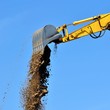 new yellow excavator working on sand dunes. Scoop close-up