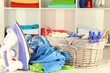 Clothes and iron on table on shelves background