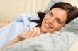 Smiling brunette woman lying in bed