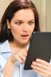 Astonished woman reading on digital tablet