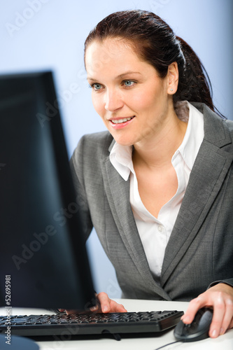 Photo: Smiling businesswoman working on her computer Smiling businesswoman working on her computer