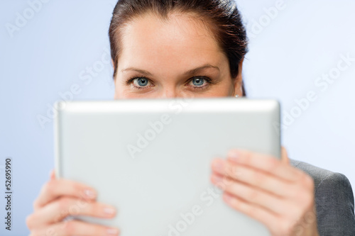 Photo: Woman holding digital tablet hiding her face Woman holding digital tablet hiding her face