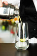 Barmen hand with shaker  pouring cocktail into glass,