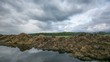 Time lapse of clouds moving and reflection in a big puddle.