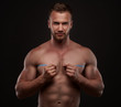 Muscular man use measurement tape