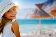 Lovely girl on tropical beach, beach chair and umbrella.