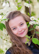 Portrait of a girl with blooming bird-cherry tree