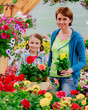 Mother with daughter shopping plants and flowers in garden cente