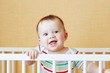 happy baby in white bed